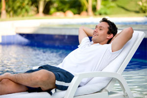 Man Relaxing by Pool in Chaise Lounge